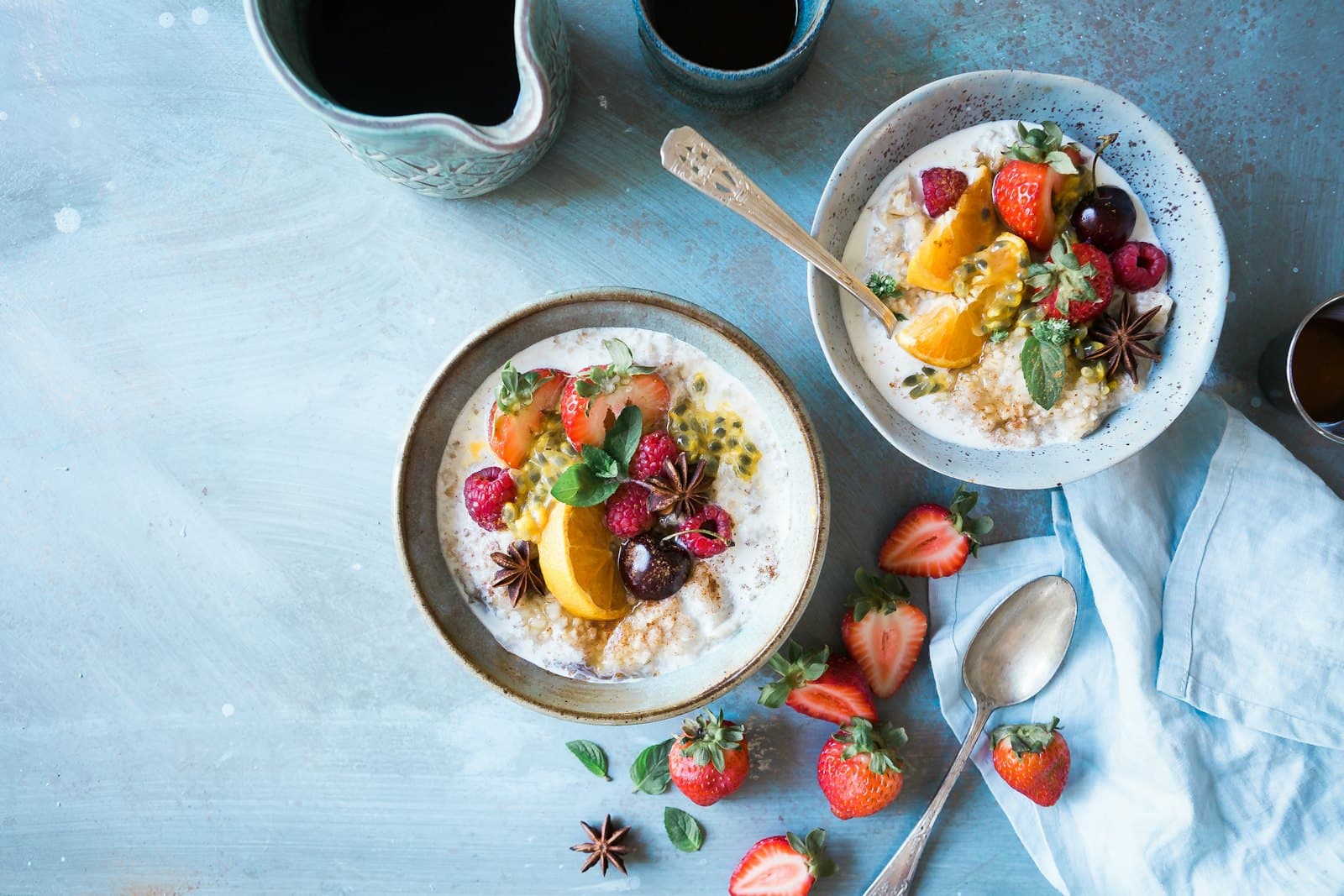 Deux bols de porridge aux fruits frais, posés sur une table claire.